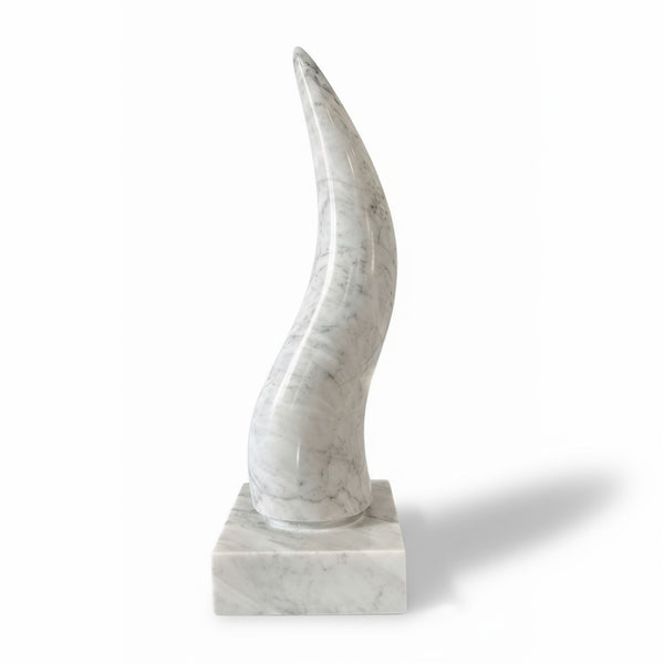 Sculpture in the shape of a horn made of veined white marble, polished and slightly curved, placed on a square base of light marble