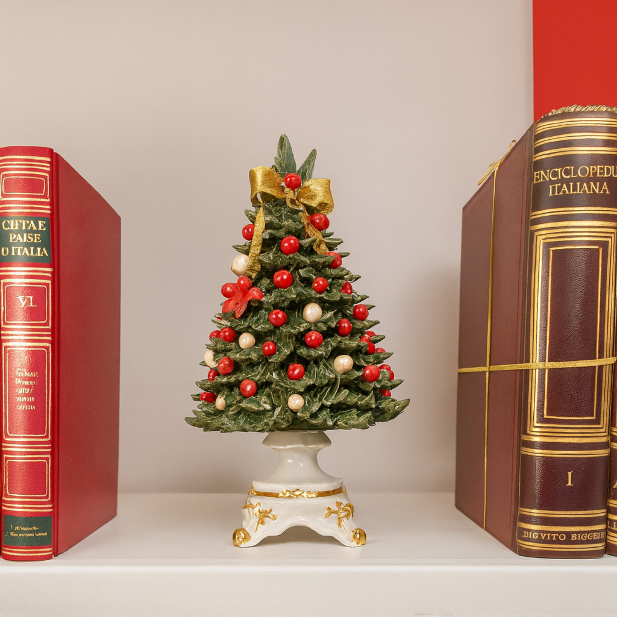 Albero natalizio in porcellana con decorazioni rosse e bianche.
