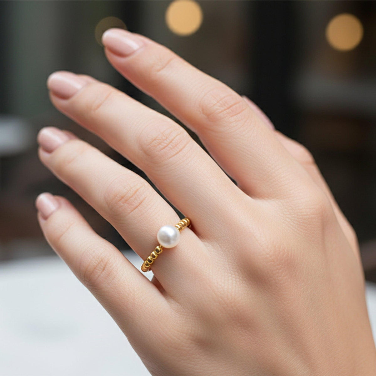 Anello di Pompei placcato oro con perla bianca, indossato sulla mano aperta
