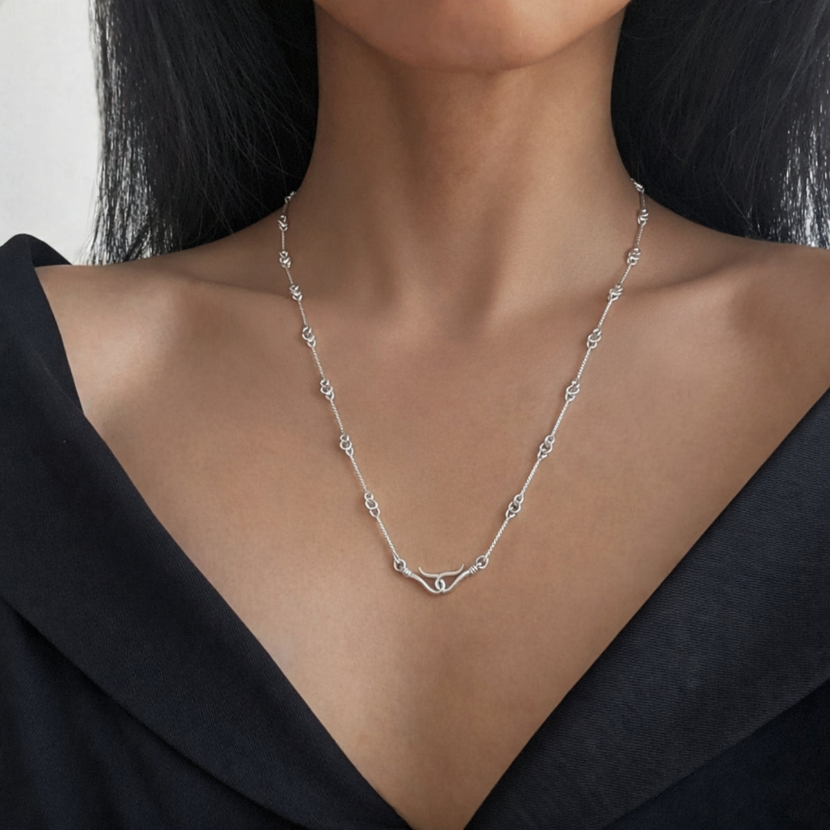 Collana con ami di Pompei in argento indossata su una maglia nera