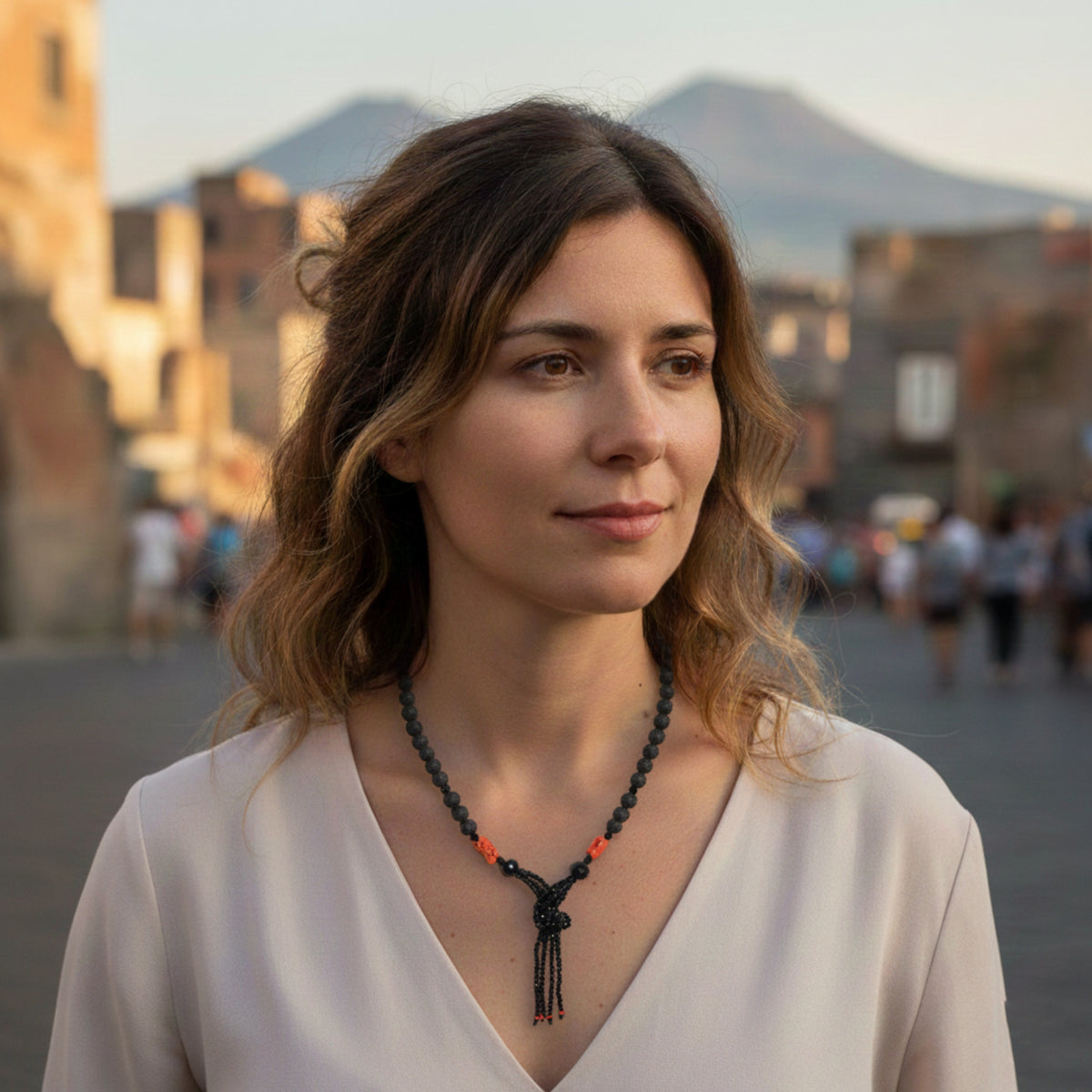 Collana serpente in pietra lavica, onice e corallo rosso indossata all'aperto