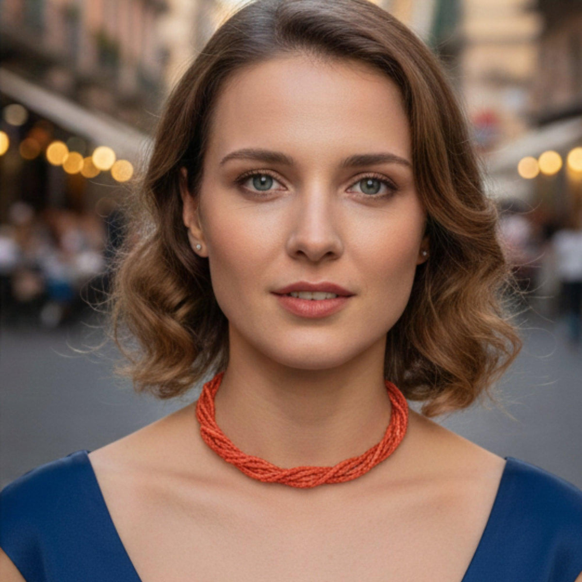 Collana torchon in corallo rosso indossata su un abito blu