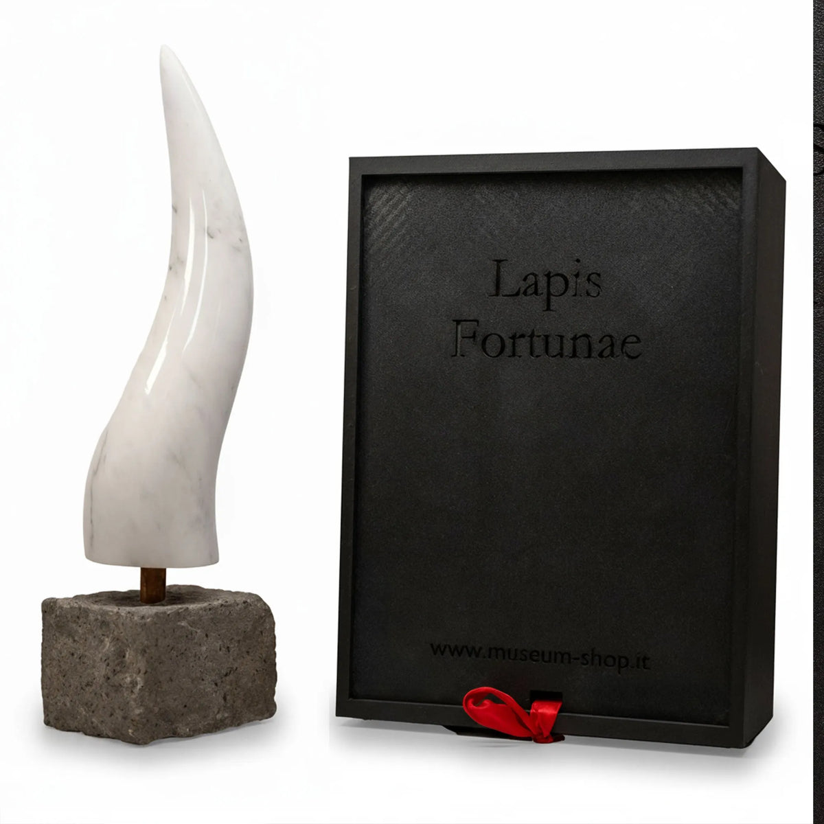 Corno in marmo di Carrara con base in pietra accanto alla confezione regalo Lapis Fortunae