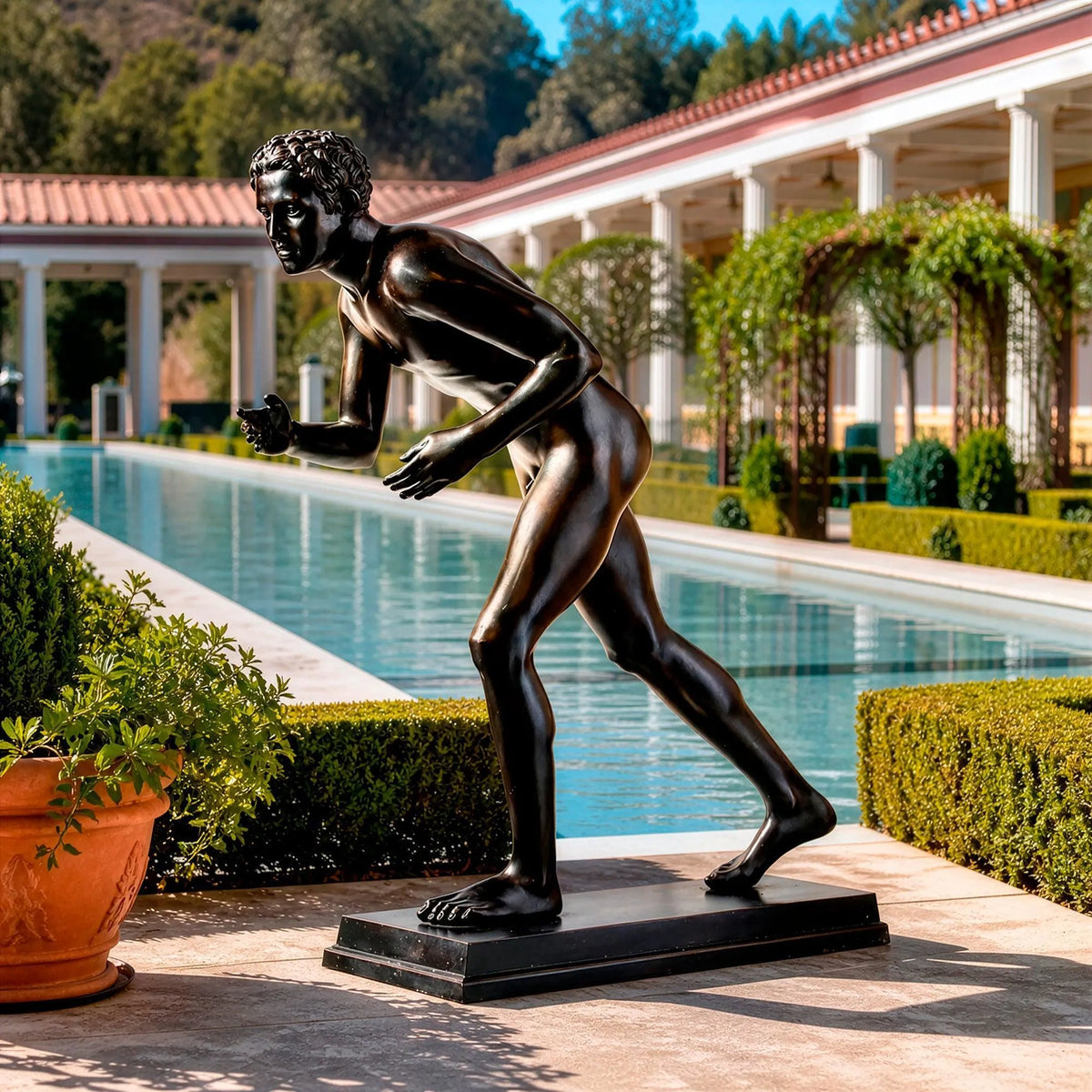 Statua del Corridore di Ercolano in bronzo scuro, in un giardino accanto a una piscina e a un colonnato.