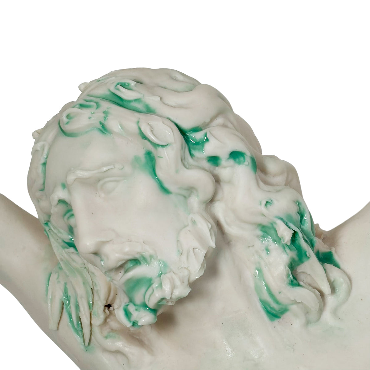 Dettaglio del volto e dei capelli di Cristo in porcellana di Capodimonte, con sfumature verdi.
