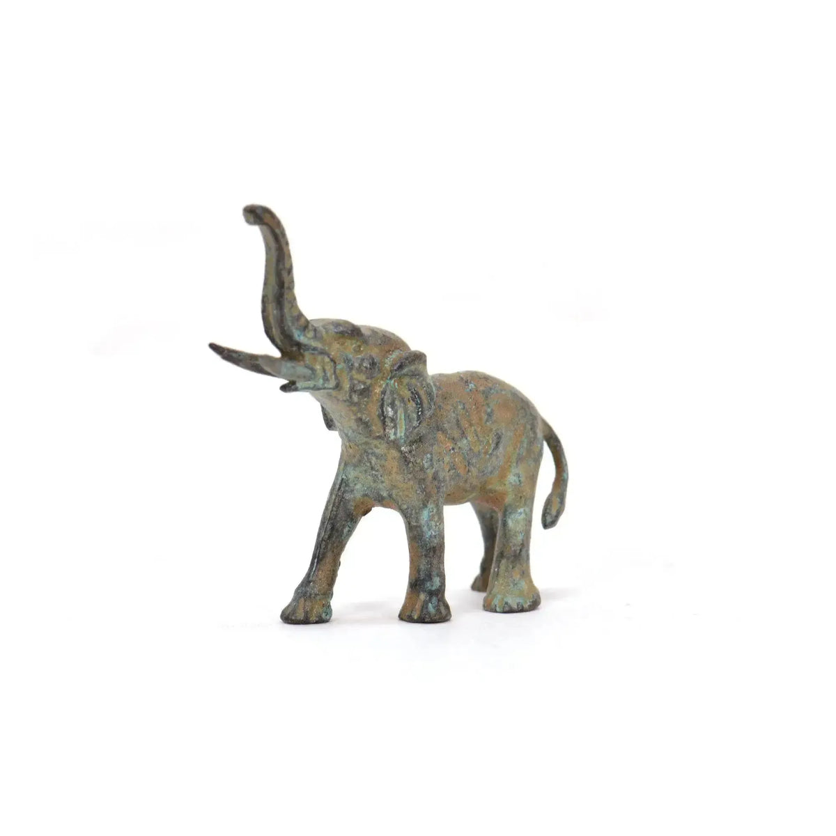 Elefante in bronzo con patina verde, proboscide sollevata e dettagli decorativi, fotografato frontalmente su fondo bianco.