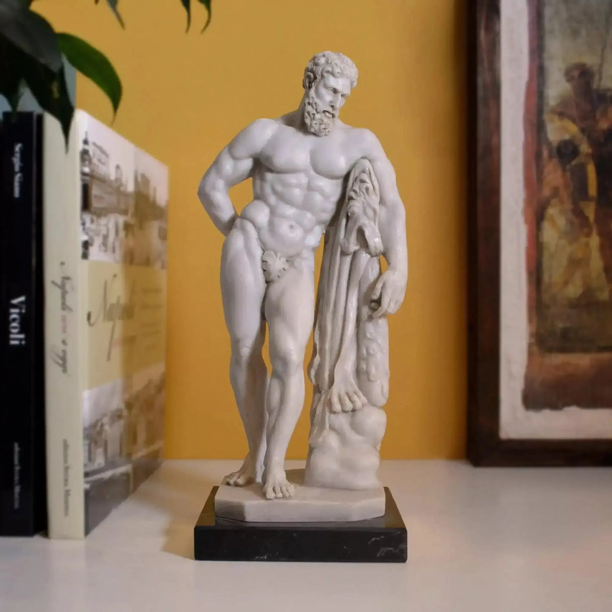 Ercole Farnese in marmo ricomposto su una mensola, accanto a libri e a un quadro
