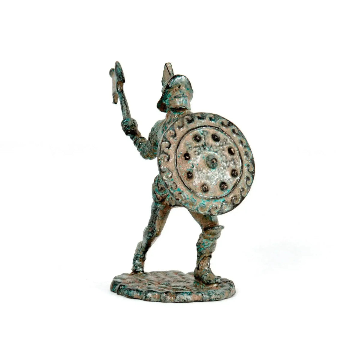 Gladiatore romano trace in bronzo con patina verde, elmo, scudo rotondo decorato e arma sollevata, fotografato frontalmente su fondo bianco.