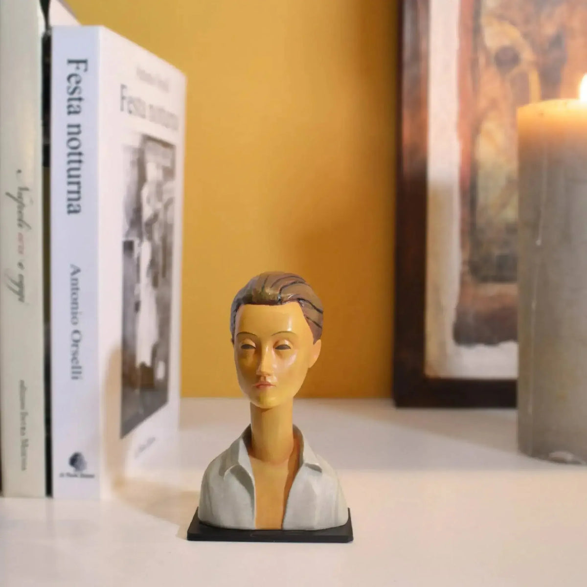 Busto di Lunia Czechowska da Modigliani, su un ripiano accanto a libri e candela