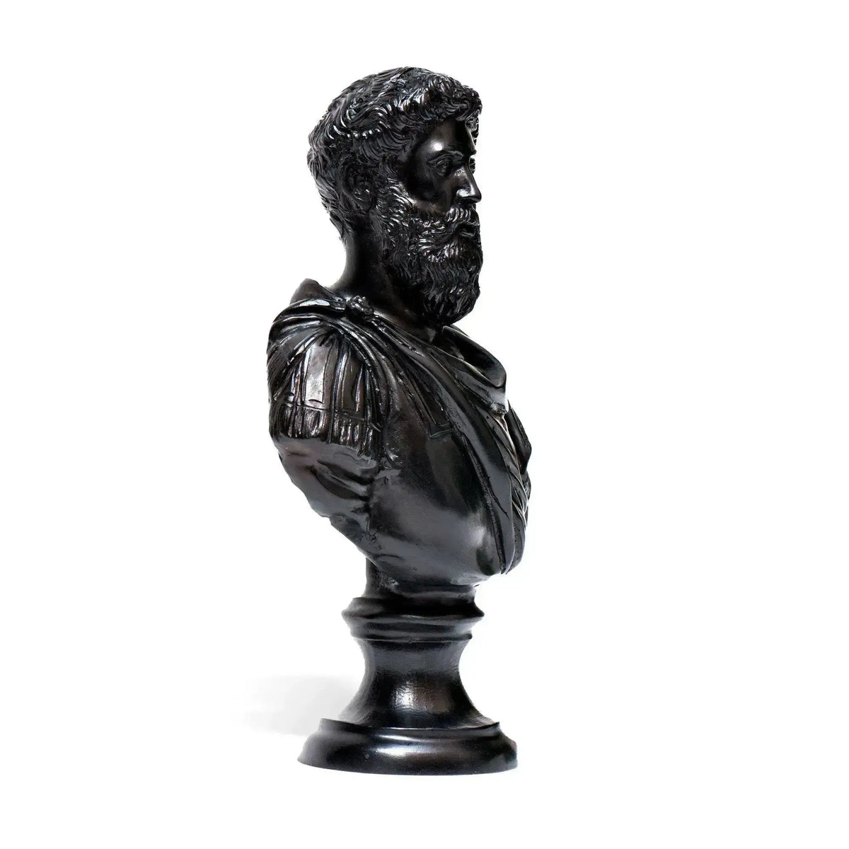 Busto di Marco Aurelio imperatore romano in bronzo scuro, fotografato lateralmente con barba dettagliata, capelli ricci, drappeggio e base rotonda.