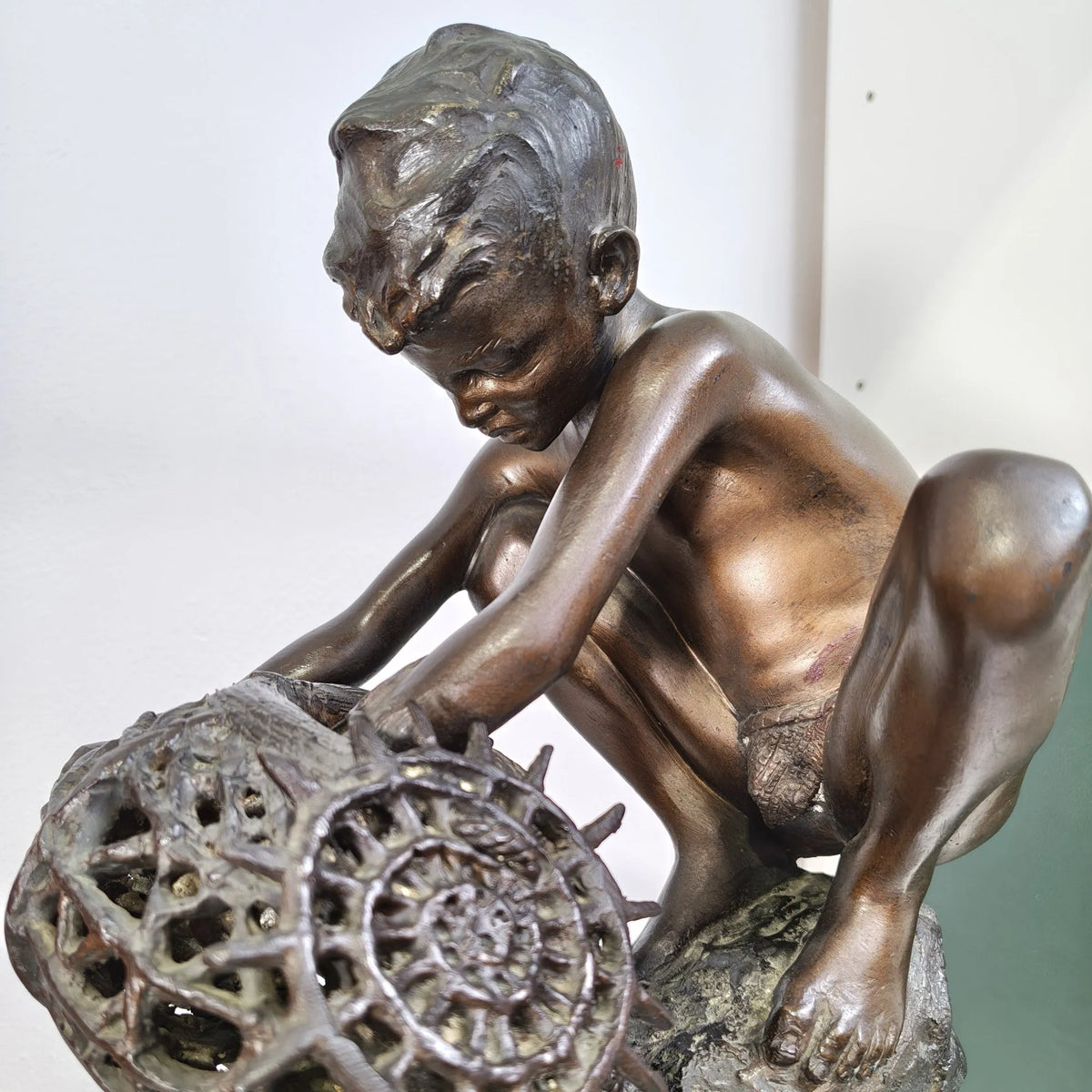 Dettaglio del volto del ragazzo pescatore in bronzo