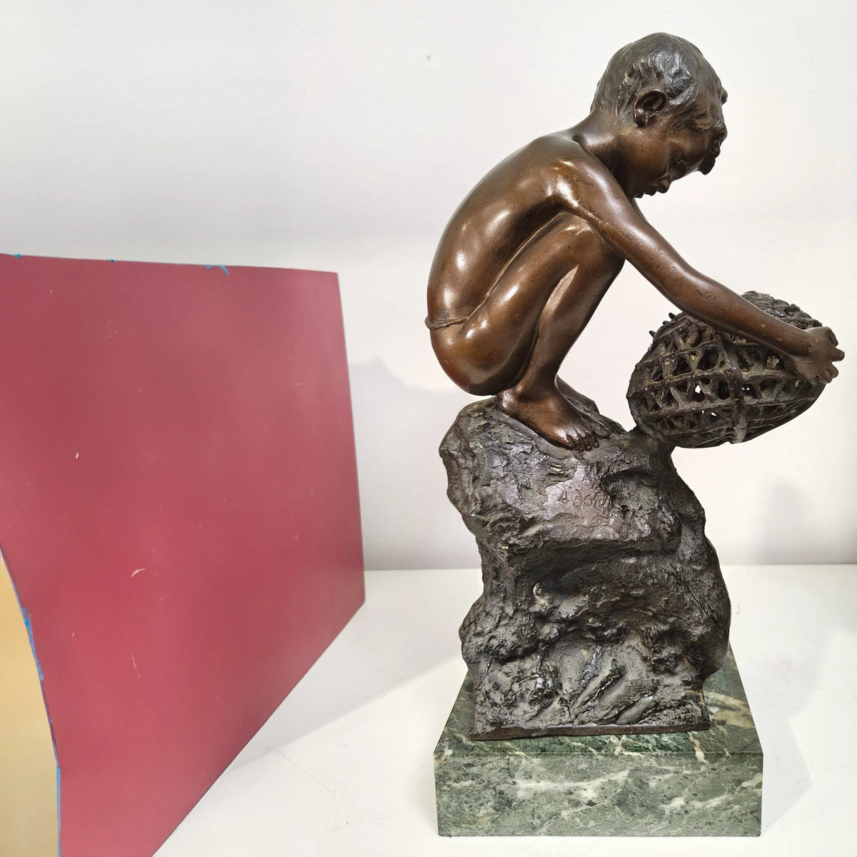 Vista laterale della scultura in bronzo Ragazzo con nassa