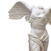 Primo piano della scultura della Vittoria Alata di Samotracia, con focus sui dettagli in marmo della statua.