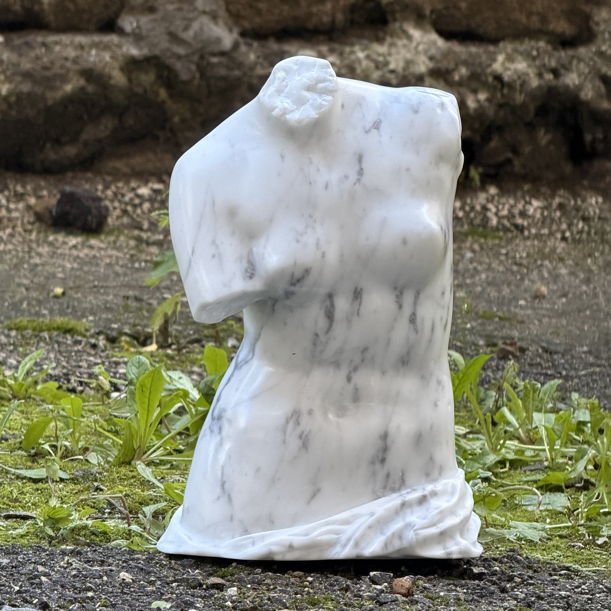 Torso di Venere all’aperto vicino a rovine.