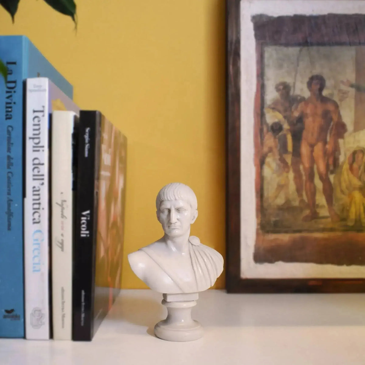 Busto di Traiano in marmo ricomposto su una mensola, accanto a libri e a un quadro