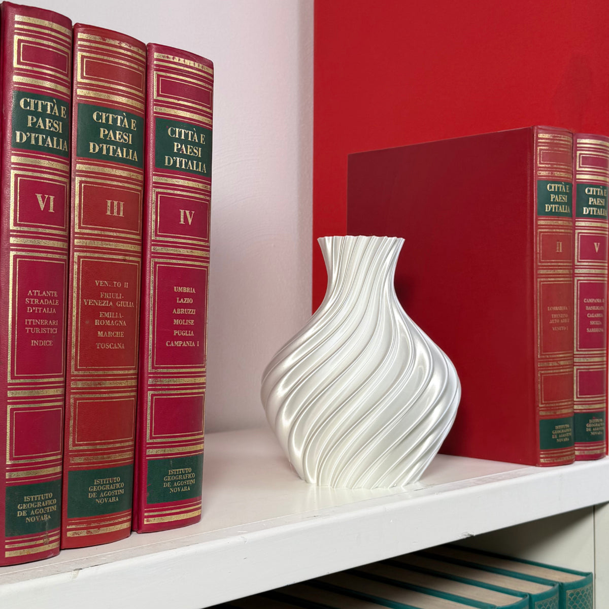Vaso bianco su mensola con libri