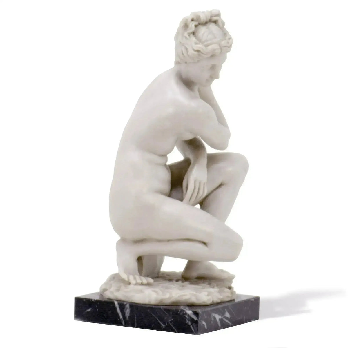 Escultura de mármol griega de Afrodita en posición agachada.