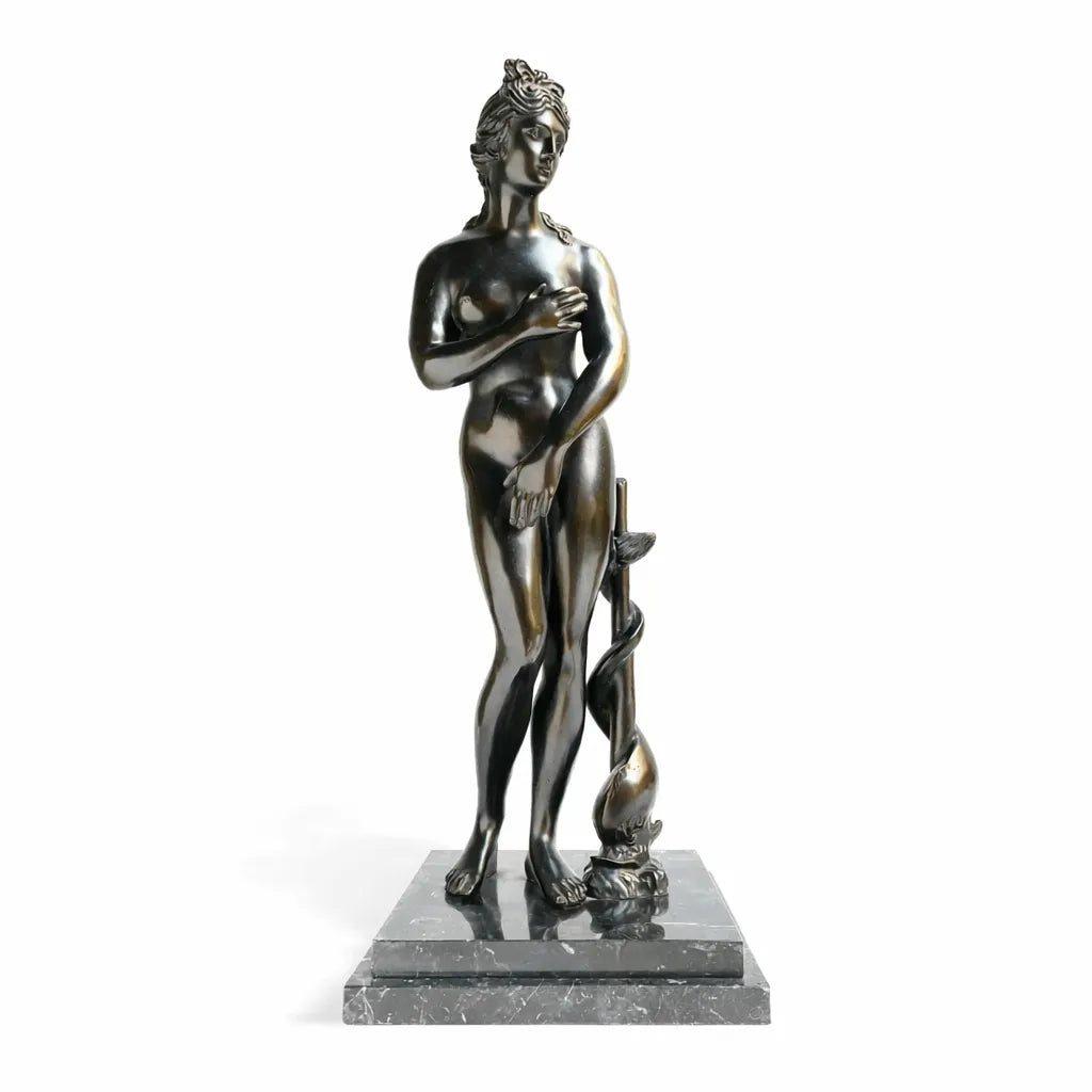 Venere dei Medici in bronzo scuro, in posa pudica su base quadrata, vista frontale su fondo bianco.
