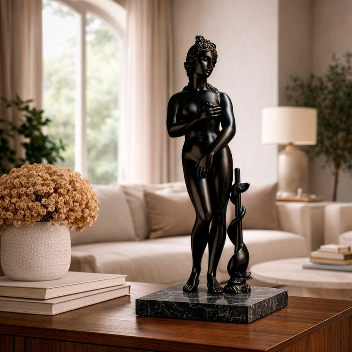 Venere dei Medici in bronzo scuro su un mobile in legno, davanti a un divano chiaro.
