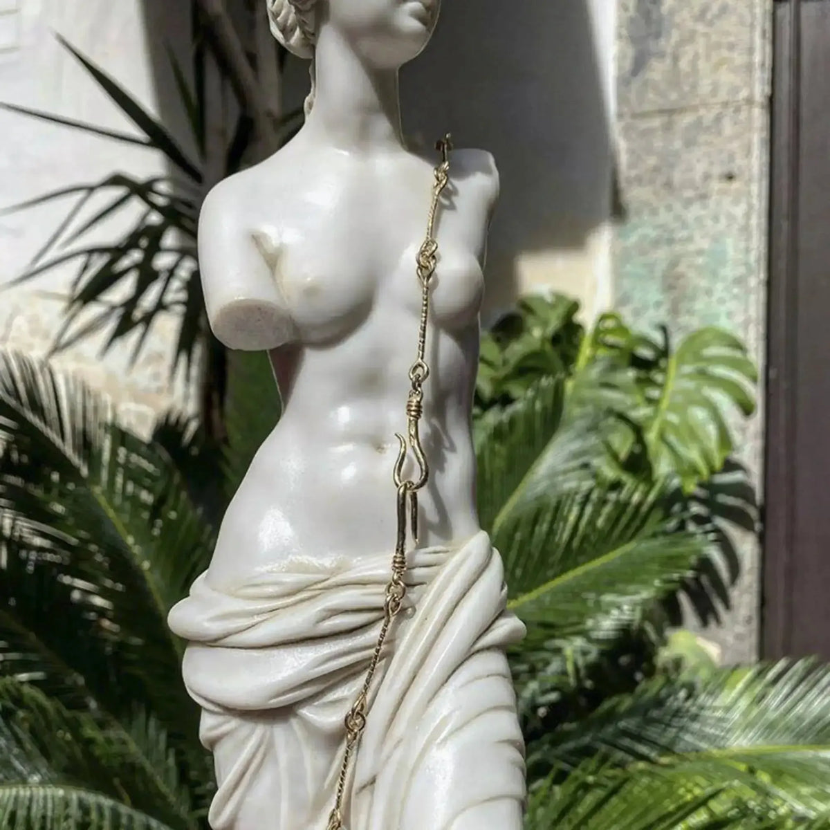 Marble Venus de Milo statue elegantly positioned in a garden.