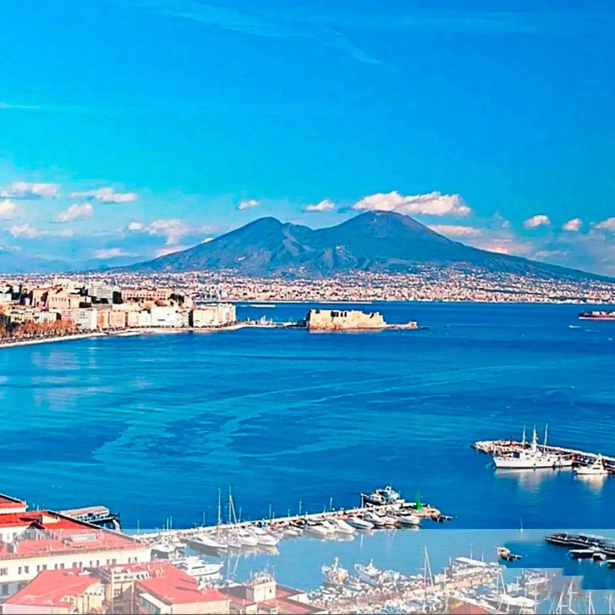 Panorama del golfo di Napoli con il Vesuvio sullo sfondo e imbarcazioni in primo piano.