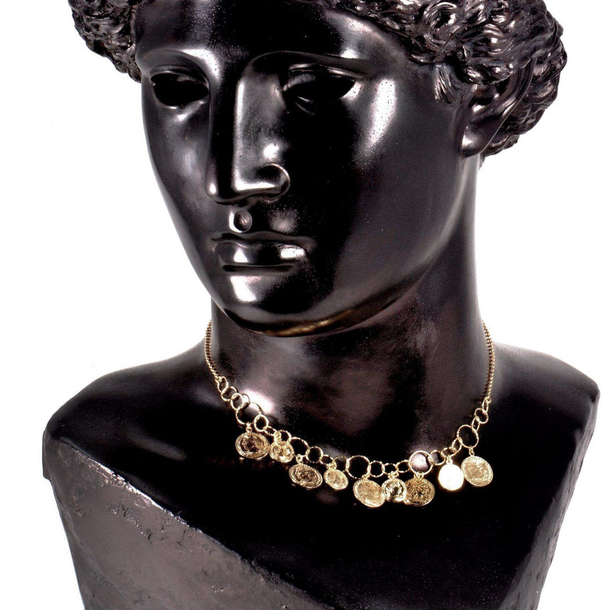 Collana con medagliette pendenti in argento dorato su un busto nero