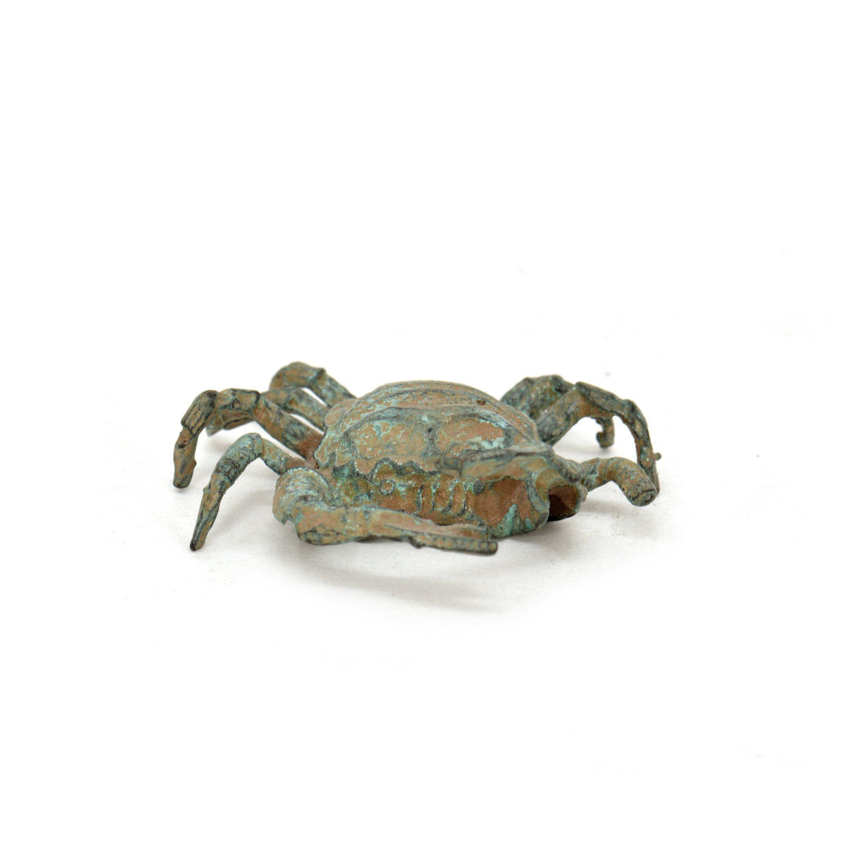 Granchio in bronzo con patina verde, statuetta decorativa fotografata frontalmente con dettagli del carapace, chele e zampe su fondo bianco.