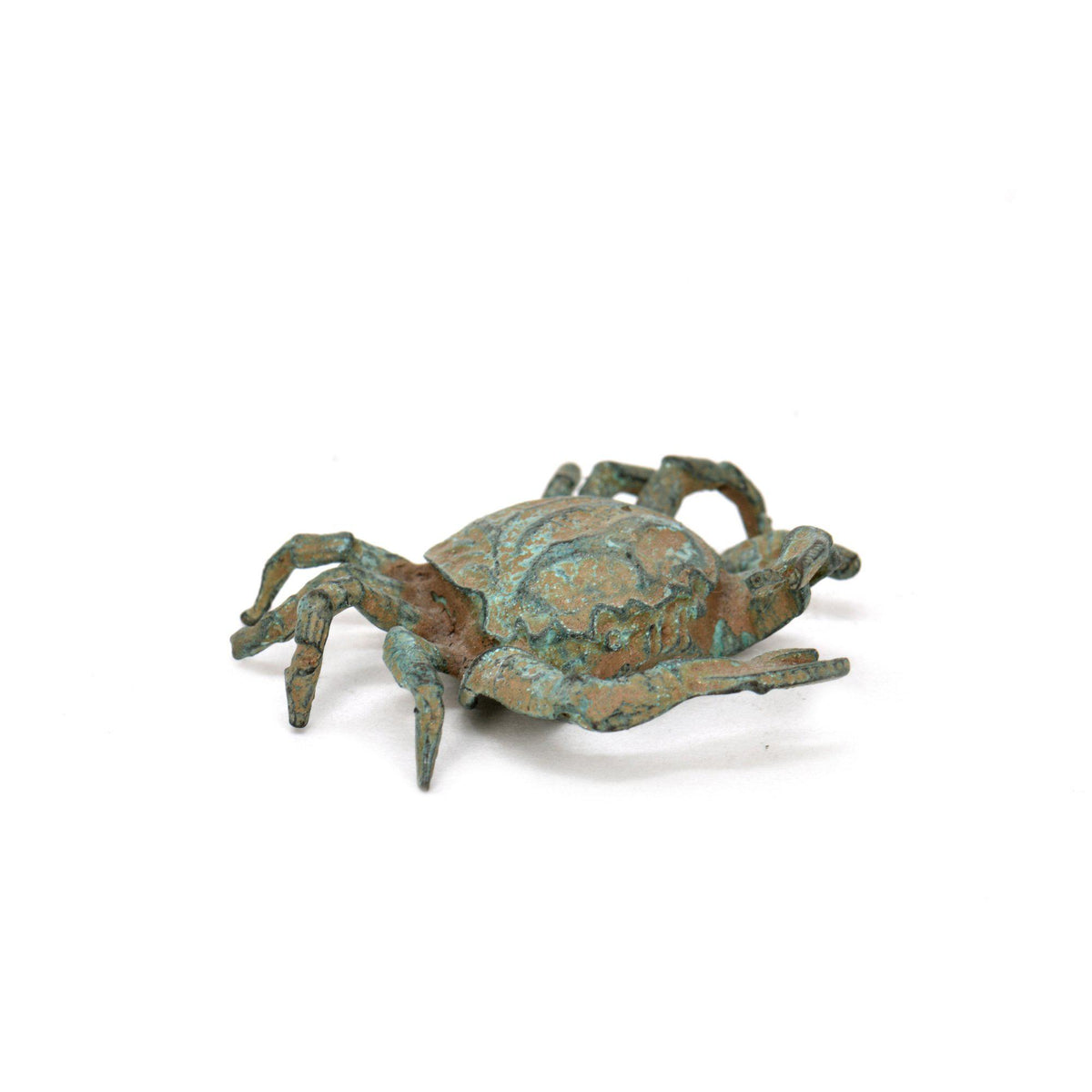 Granchio in bronzo con patina verde, statuetta decorativa con dettagli del carapace, chele e zampe, fotografata su fondo bianco.