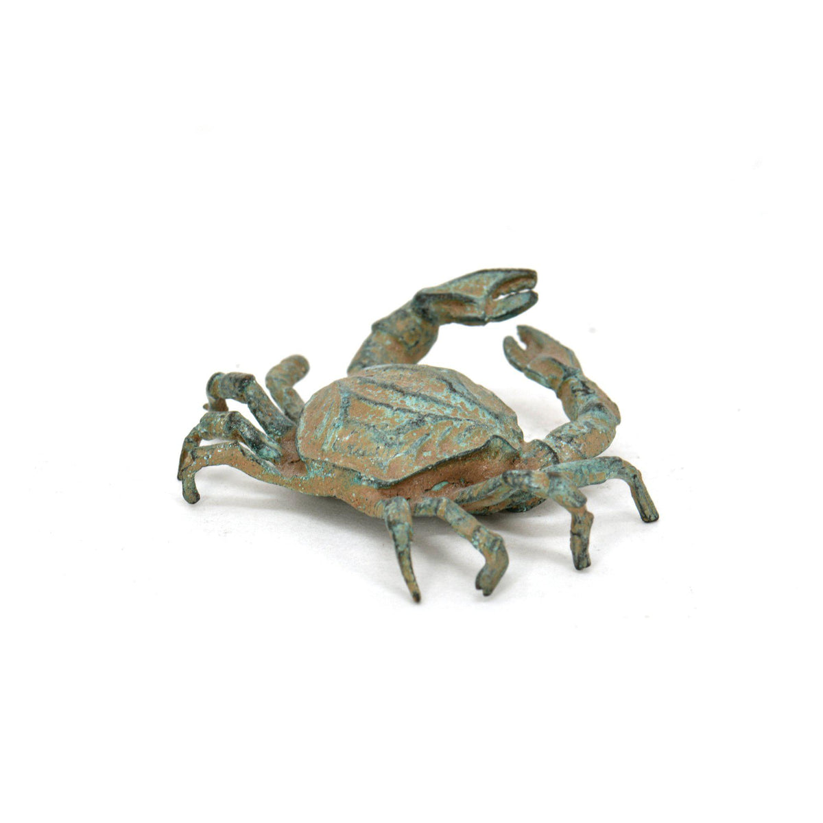 Granchio in bronzo con patina verde, statuetta decorativa fotografata di tre quarti con dettagli del carapace, chele e zampe su fondo bianco.