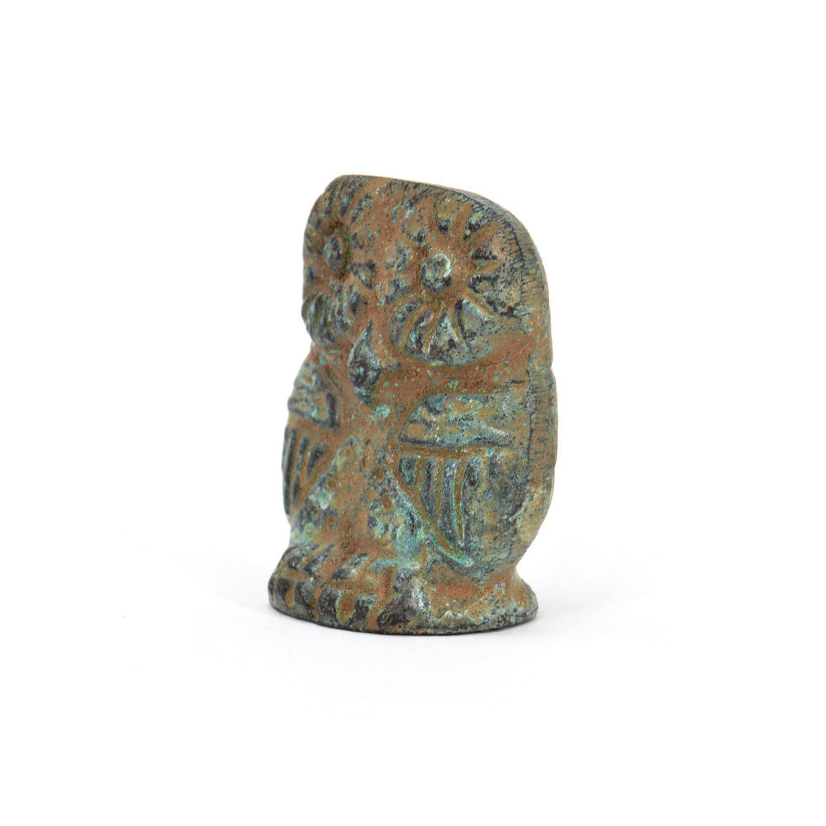 Gufo in bronzo con patina verde, visto di tre quarti con occhi e ali incisi, su fondo bianco.