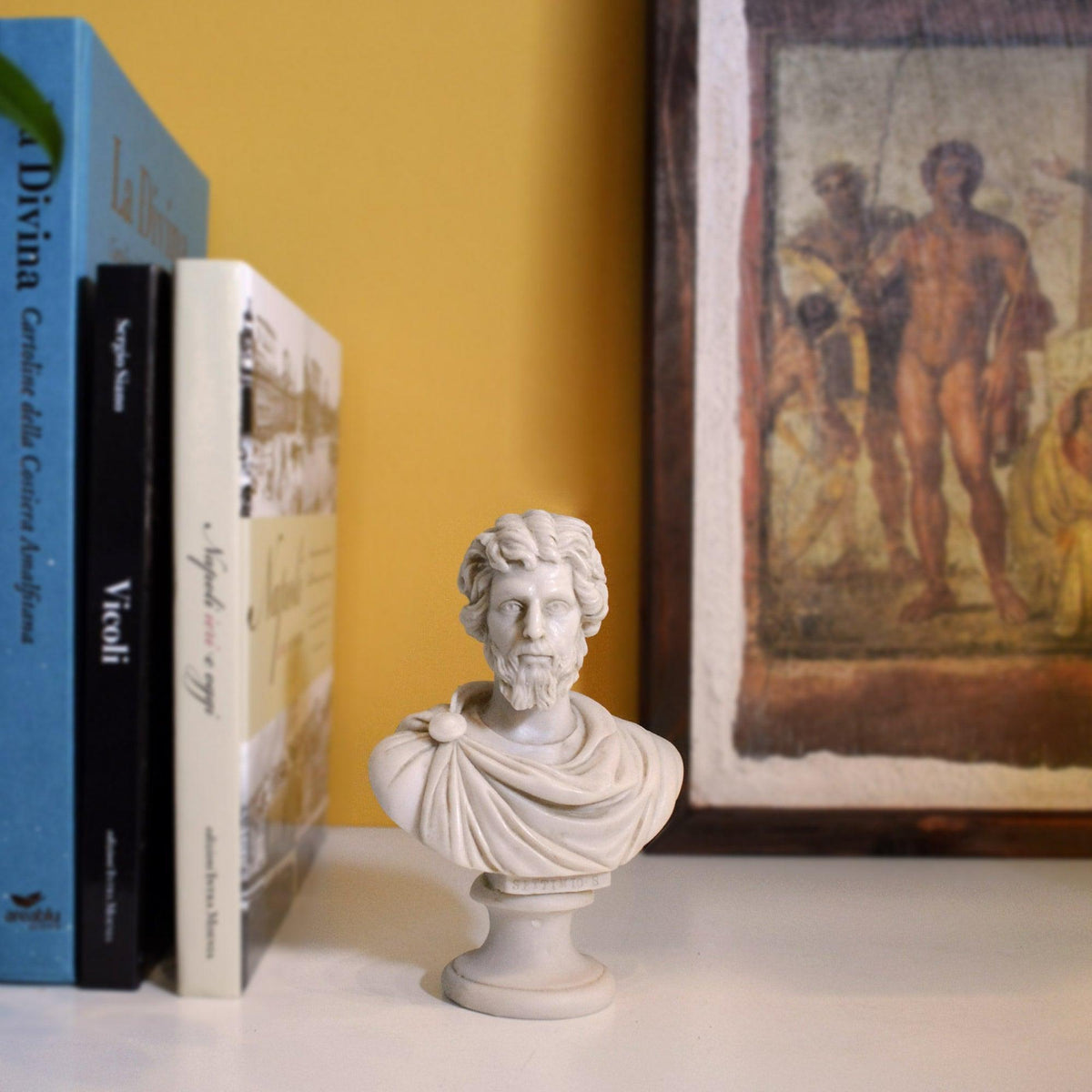 Busto di Settimio Severo in marmo ricomposto su una mensola, accanto a libri e a un quadro